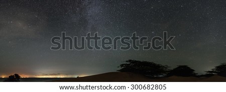 Wide angle view of the Milky Way, taken from the venezuelan deserts in Paraguana peninsula. At the distance, the city lights from Aruba island are visible.