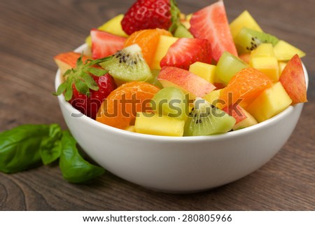 Fruits salad in bowl on wooden table