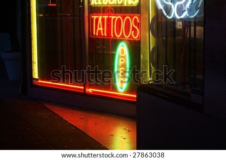 Tattoo shop sign glowing at night in 