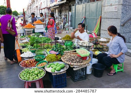 Yangon, Myanmar - Jan 14, 2015. Burmese women selling fresh fruits at Bogyoke market in Yangon, Myanmar.