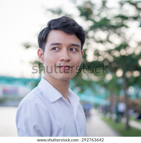 Portrait of young handsome man of Asian thinking and watching.