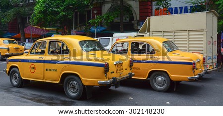 KOLKATA, INDIA - JUL 8, 2015. Yellow Ambassador taxi cars go on the street in Kolkata, India. First Ambassador was produced by the Yellow Cab Manufacturing Company in 1921.