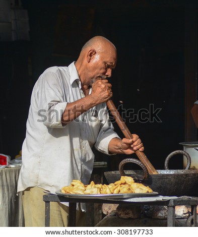 DELHI, INDIA - JUN 16, 2015. Unidentified market vendor selling food in a local restaurant in Delhi, India. Street foods in India are reasonably priced and easily available.