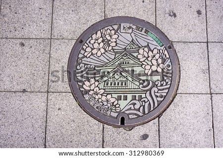OSAKA, JAPAN - AUG 17, 2015. Manhole cover in Osaka, Japan. The Osaka castle engraved on to a manhole cover as a symbol of an important city\'s landmark.