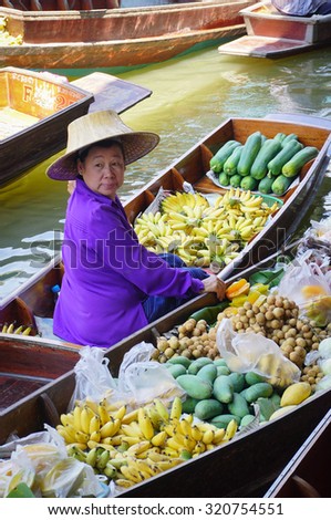 Bangkok, Thailand - May 22, 2015. A Thai woman selling fresh fruits on the Damnoen Saduak floating market in Thailand. This is the most famous of the floating markets in Thailand.