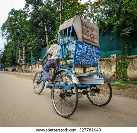 DELHI, INDIA - AUGUST 29, 2015. Unidentified Indian trishaw driver running on the street in Old Delhi, India. Bicycle rickshaw on the street of Delhi.