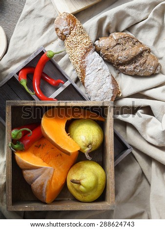 Bread, pumpkin, pears and hot chili peppers on linen