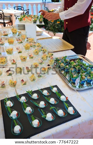 stock photo Waiter placing fingerfood appetizer for a wedding buffet on a 