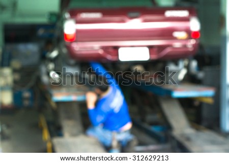 Blurred background : Car technician repairing the car in garage