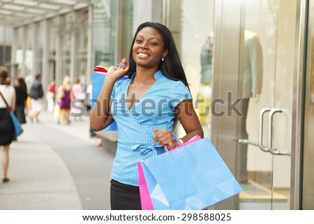 Young woman with shopping bags outside of store.