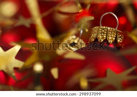 Red Christmas Balls and gold stars with shallow depth of field and focus on gold cap