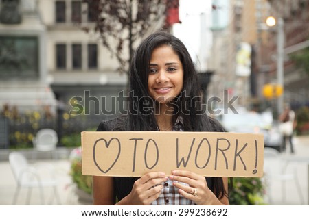 Young woman holding a sign that says love to work with heart symbol.