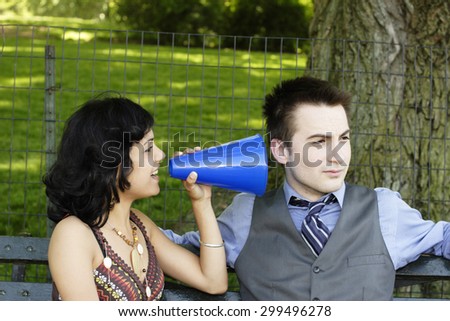 Man ignoring woman with megaphone.