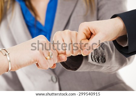 Close-up of three businesswomen putting their fists together in a \