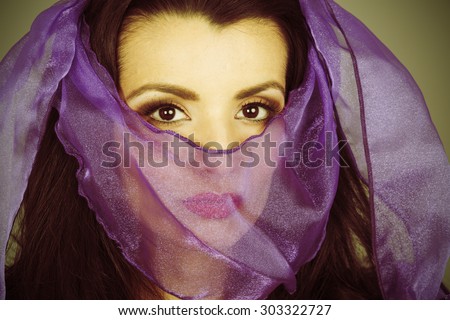 Woman with veiled face. Processed to look as if a vintage color photograph with mild cross processing.