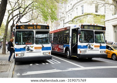 New York, New York, USA - April 15, 2012: Two buses side by side on Fifth Avenue in Manhattan. One bus is stopped and taking on a passenger. This shot was taken on Fifth Avenue near Central Park.