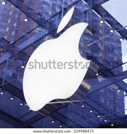 New York, New York, USA - March 8, 2012: The Apple logo sign in the upper west side Apple store in Manhattan. Reflections of buildings and sky can be seen in the window glass.