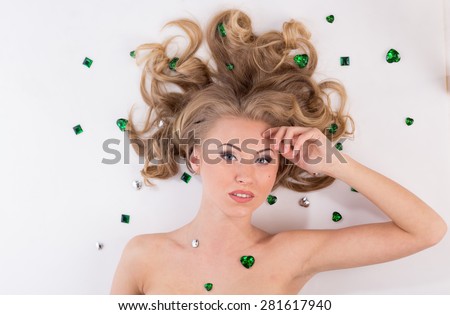 Young woman with  beautiful make up and green diamonds on the white floor