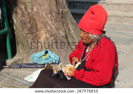 KATHMANDU, NEPAL - OCT 4:  A homeless woman begging sits beside the road to rest after begging to the people passing by on October 10, 2012 in Durbar Square-Kathmandu-Nepal