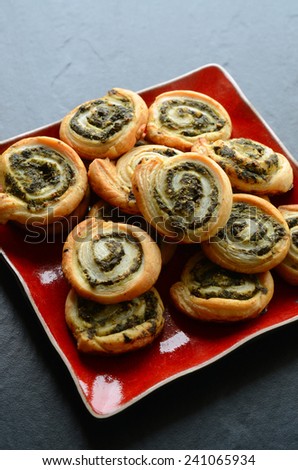 Puff pastry rolls with spinach and greek cheese filling on a stone plate