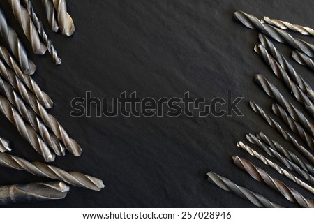 Set of old, worn drill bits on a dark table