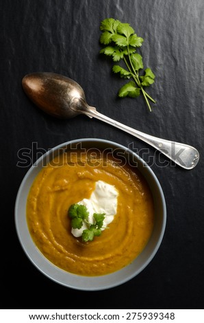 Bowl of fresh homemade sweet potato soup with ricotta cheese and coriander leaves