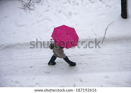 CIRCA DECEMBER 2010 - BERLIN: person with colorful umbrella in a winter scene in Berlin.