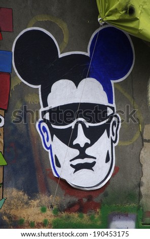 CIRCA MARCH 2014 - BERLIN: street art/ graffiti in Berlin: man with Mickey Mouse easr.