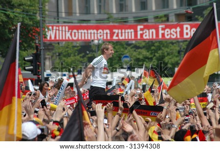 BERLIN, JULY 9, 2006: Juergen Klinsmann and the German fans celebrate the 3rd place in the soccer world championship 2006 in front of the Brandenburg Gate in Berlin on July 9, 2006