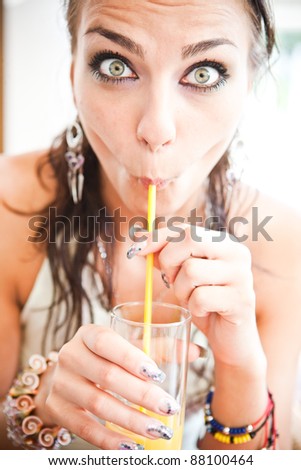 women with funny face expression drinking water from a glass