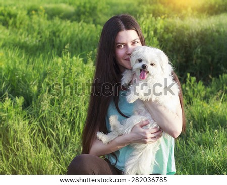 Beautiful girl with a young dog enjoying a beautiful day in the outdoors