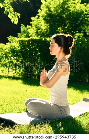 Young beautiful woman doing yoga in the park in the morning