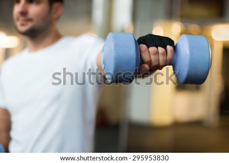 sport and recreation concept - sporty men hands with light blue dumbbells