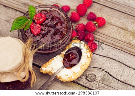 Toast with raspberry jam - homemade marmalade with fresh fruits from garden. All in rustic decoration, Fruit jam on toasted bread.
