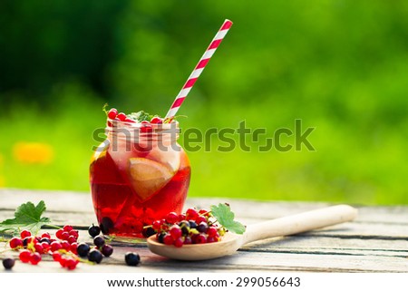 Iced Red currant drink on wooden table.Selective focus