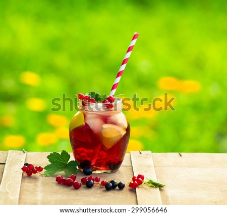 Iced Red currant drink on wooden table.Selective focus