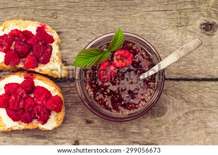 Toast with raspberry jam - homemade marmalade with fresh fruits from garden. All in rustic decoration, Fruit jam on toasted bread.