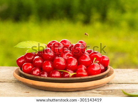 Cherries on wooden table with water drops macro background. DOF