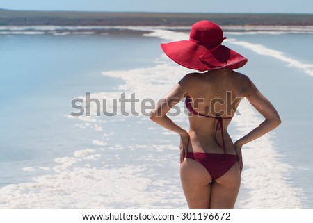 The lake with salt water. Sexy back of a beautiful woman in a red bikini