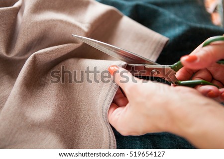 Tailor. Woman Hands notch tailor tailor\'s scissors cloth. Close Up.