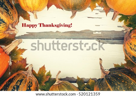 Thanksgiving. Toned image. Ripe pumpkin and autumn fallen leaves on a white vintage board. Decorated background, greeting card Thanksgiving Day. Happy Thanksgiving Day!