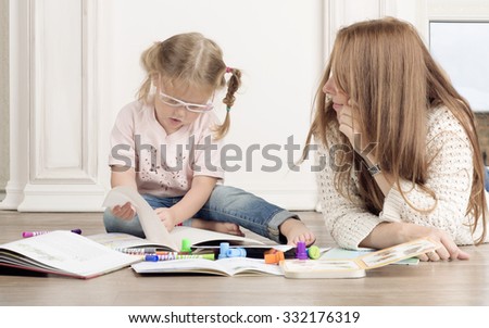 Woman helps a child to draw.