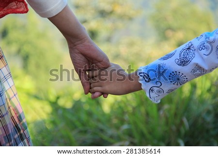 Mommy hold my hand /mommy hold daughter\'s hand in the garden