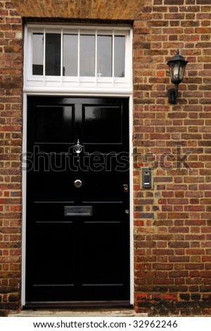 Shiny gloss black door with an electric lantern and doorbell