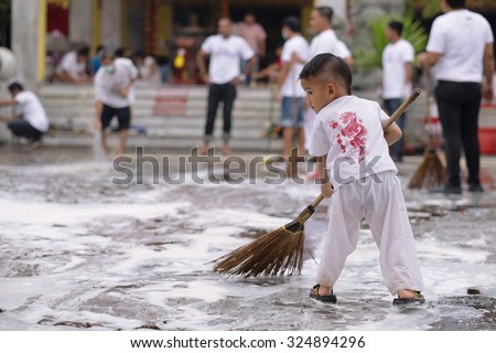 PHUKET THAILAND : OCTOBER 7 : A young boy devotee cleans floor to be prepared for Phuket Vegetarian Festival coming on 13-21 October in Jui Tui shrine on October 7, 2015