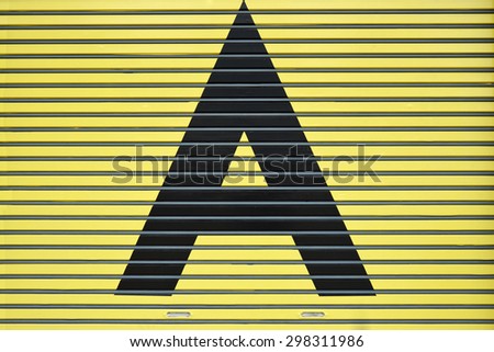 Black letter A painted on yellow steel roller shutter door