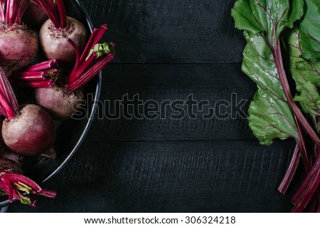 Beets in a round bowl on a black wooden background