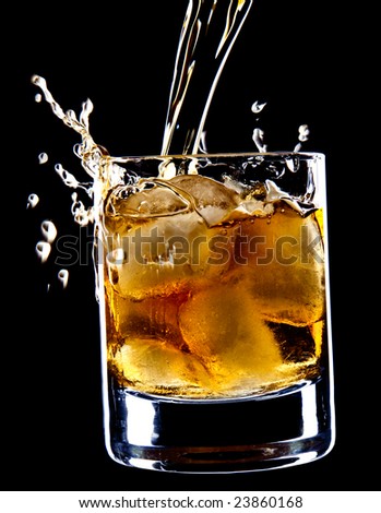 glass of whiskey and ice under the pouring whiskey isolated over black background