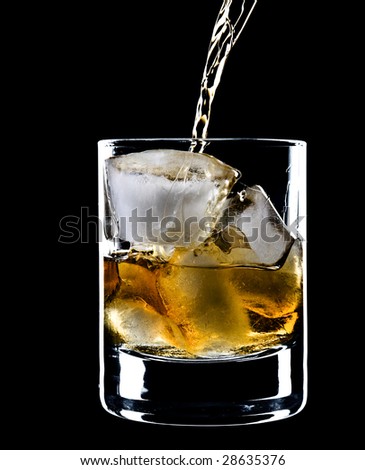 glass of whiskey and ice under the pouring whiskey isolated over black background