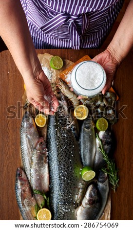 Female hand salted fish and home-cooked marinade, housewife preparing dinner for a large family